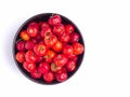 Top view of ripe red acerola cherries fruit in a ceramic bowl isolated on white background. Royalty Free Stock Photo