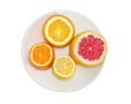 Top view of partly cut various citrus on white dish