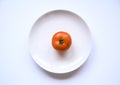 Top view of a ripe  red tomato on a white plate Royalty Free Stock Photo