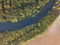 Top view of the river with turns of meanders and green forests in bright sunlight. Creek in the park among the trees. Aerial