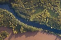 Top view of the river with turns of meanders and green forests in bright sunlight. Creek in the park among the trees. Aerial