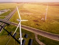 Top VIEW of road passing near wind farms and solar panels in middle of green field Royalty Free Stock Photo