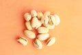 Top view of roasted pistachios in shell on orange background