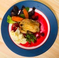 Top view of roasted quail with caramelized carrots and cranberry sauce