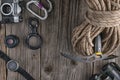 Top view of rock climbing equipment on wooden background. Chalk bag, rope, climbing shoes, belay/rappel device, carabiner and asce
