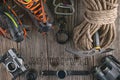 Top view of rock climbing equipment on wooden background. Chalk bag, rope, climbing shoes, belay/rappel device, carabiner and asce