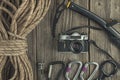 Top view of rock climbing equipment on wooden background. Chalk bag, rope, climbing shoes, belay/rappel device, carabiner and asce