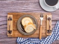 Top view of roll cake on a plate on a wooden tray with a cloth and a white coffee cup on a wooden table. Royalty Free Stock Photo