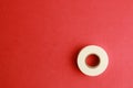 Top view of a roll of insulating tape on a red surface under the lights