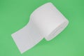 Top view of roll of white toilet paper with perforation on a green background Royalty Free Stock Photo