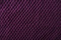 Texture of dark purple knitted fabric as a background.Empty space for design