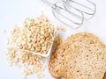 Top view of rolled oat flakes whole grain in bowl and whole wheat bread isolated on white background Royalty Free Stock Photo