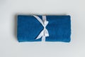 Top view of a rolled up terry blue towel on a light gray background