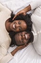 Top view of romantic afro couple lying in bed together Royalty Free Stock Photo