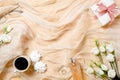 Top view romantic background with morning coffee cup, marshmallows, perfume, gift box and rose flowers. Flat lay feminine desk