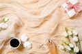 Top view romantic background with morning coffee cup, marshmallows, perfume, gift box and rose flowers. Flat lay feminine desk