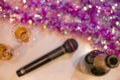 Top view of romantic couple of champagne flutes and bottle of sparkling wine with black karaoke microphone and pink garland.