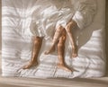 Top view of romantic couple sleeping. bare feet of their legs lying in a bed with white blanket in love and sex concept in modern Royalty Free Stock Photo