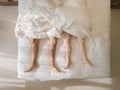 Top view of romantic couple sleeping. bare feet of their legs lying in a bed with white blanket in love and sex concept in modern Royalty Free Stock Photo
