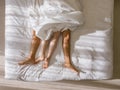 Top view of romantic couple sleeping. bare feet of their legs lying in a bed with white blanket in love and sex concept in modern Royalty Free Stock Photo