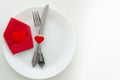 Top view romantic dinner proposal concept. Dish with cutlery and red gift box with heart. Copy space for lettering or