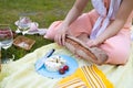 Top view of romantic picnic composition with cheese and strawberry. Young woman preparing food on picnic.