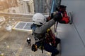 Top view of rope access abseiler wearing full body safety harness hard hat abseiling working at height