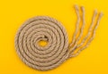 Top view of rope spiral with unraveled end on yellow background Royalty Free Stock Photo