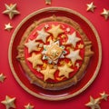 Top view of Roscon de reyes on a red plate with golden stars. Kings day concept spanish three kings cake