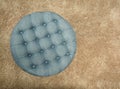 Top view of round fabric blue pouf with buttons and squares on brown carpet Royalty Free Stock Photo