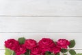 Top view of row of red roses on white wooden background, lots of copyspace. Greetimgs with valintines day,