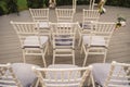 rows of white chairs decorated with flowers at a wedding ceremony in the garden Royalty Free Stock Photo