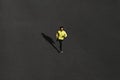 Top view runner man running sprinting for success on run at black road in yellow sportswear. Muscular fit sport model sprinter ex