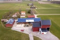 Top view of rural landscape on sunny spring day. Farm with solar photo voltaic panels system on wooden building, barn or house