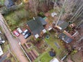 Top view at rural timber house with some barns. Several cars parking in yard. Russia