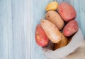 top view of russet red and new potatoes spilling out of sack on wooden background with copy space Royalty Free Stock Photo