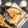 Top view of the Russian dish pancakes, milk, jam, white chocolate, towel, potholder, knife and fork Royalty Free Stock Photo