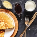 Top view of the Russian dish pancakes, milk, jam, white chocolate, towel, potholder, knife and fork Royalty Free Stock Photo