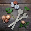 Arrangement with culinary condiment and wooden spoon on a plank