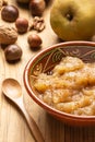 Top view of a rustic bowl with applesauce with cinnamon, on a table with pippin apples and nuts, Royalty Free Stock Photo
