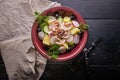 Top view rustic salad with octopus tentacles, boiled potatoes, cucumbers, fresh radishes, olives and dill