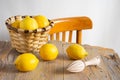 Top view of rustic table with basket with lemons and wooden juicer, white background with chair, Royalty Free Stock Photo