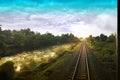 Top view of the rusty rails crossing the green field in a summer day , Northern Railway Thailand