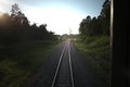 Top view of the rusty rails crossing the green field in a summer day , Northern Railway Thailand