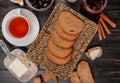 top view of rye bread slices in basket plate with cup of tea butter knife cinnamon olive jam on wooden background Royalty Free Stock Photo