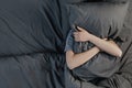 Top view of sad depressed young woman lying on bed covering head with pillow feels unhappy and lonely Royalty Free Stock Photo