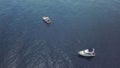 Top view of sailing boats and a man swimming in the open sea. Video. Amazing aerial view of two white yachts in deep Royalty Free Stock Photo