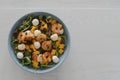 Top view of salad with mango, mozzarella, shrimps and mixed microgreens in blue bowl on white oak table Royalty Free Stock Photo