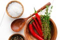 Top view: salt, pepper, chili and thyme in bowls on white wooden table