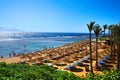 Top view of the sandy beach. Palm trees and stunning landscape of the Red Sea. Wicker umbrellas and sun loungers for holidaymakers Royalty Free Stock Photo